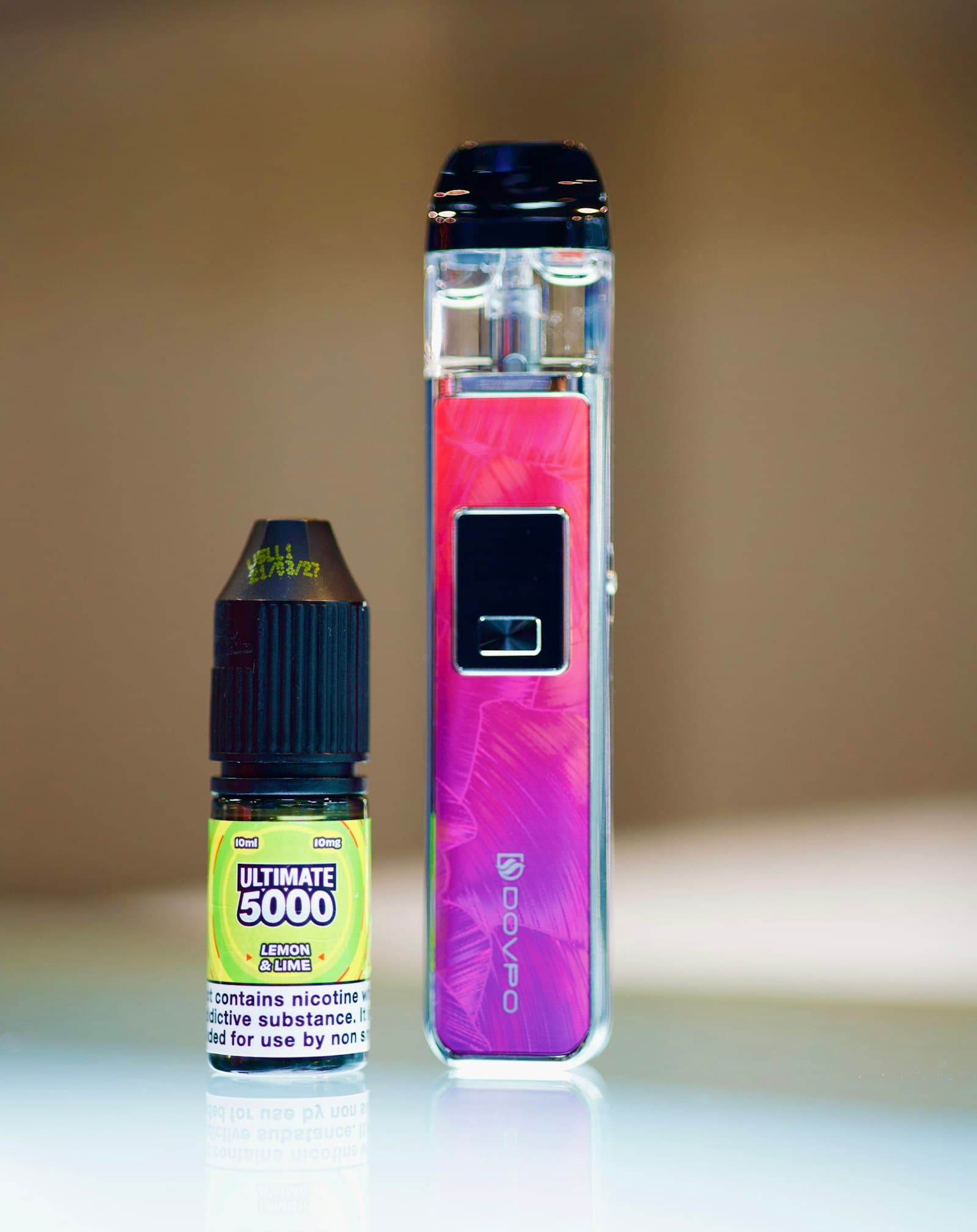 A 10ml nic salt e-liquid bottle standing next to a compact pod vape device